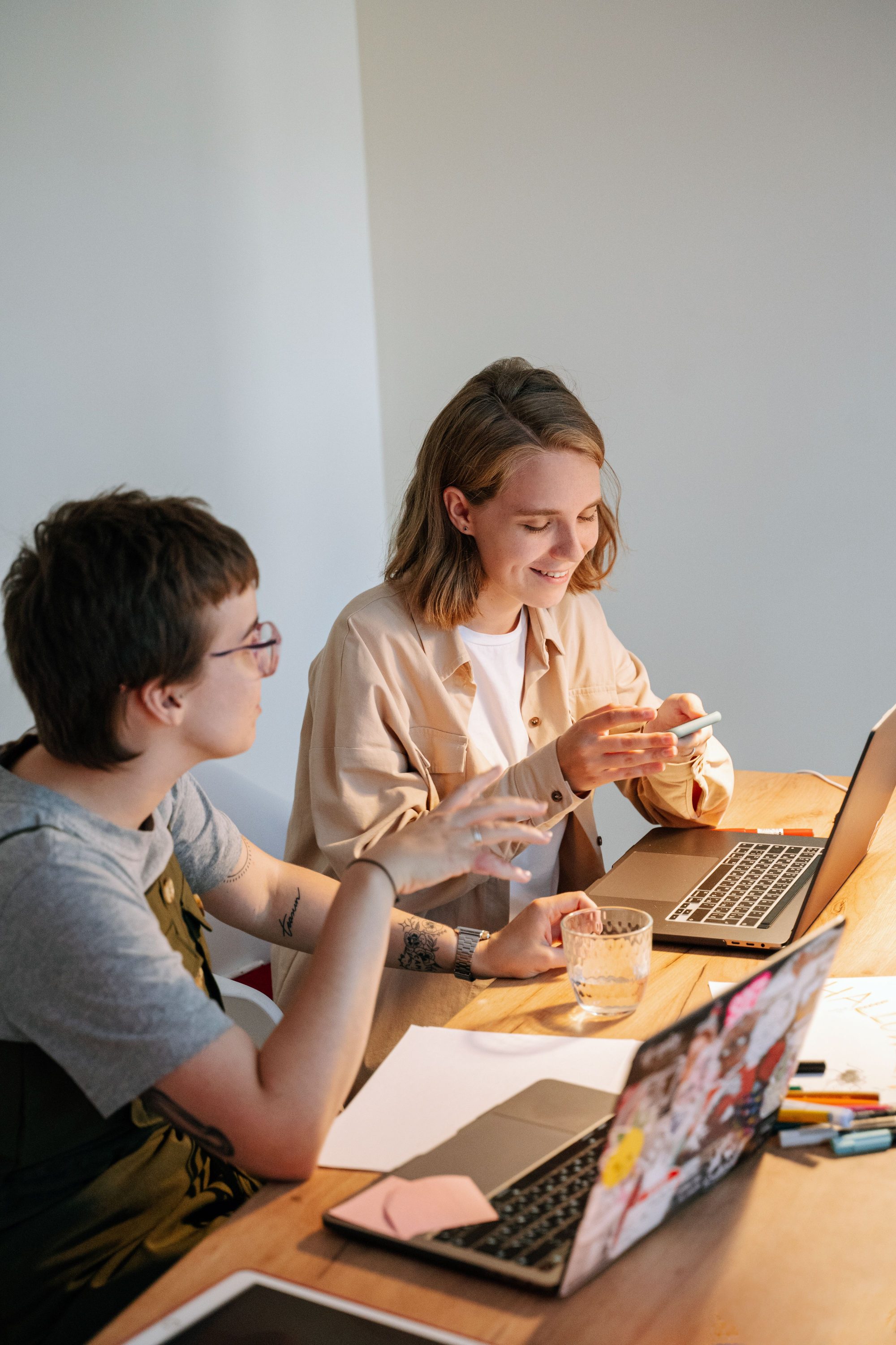 Two members collaborating over laptops at a sunlit table at Northline Collective.